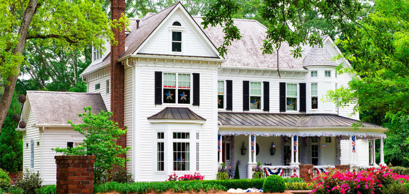 White Home With American Flag Decorations | Select Home Warranty