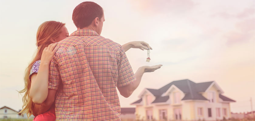 A couple stands outside of their new home. | Select Home Warranty