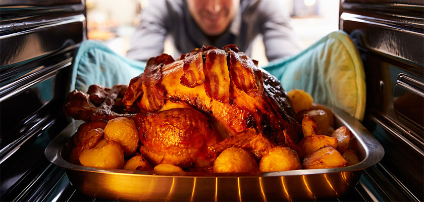 A man cooking a turkey in a clean oven. | SHW