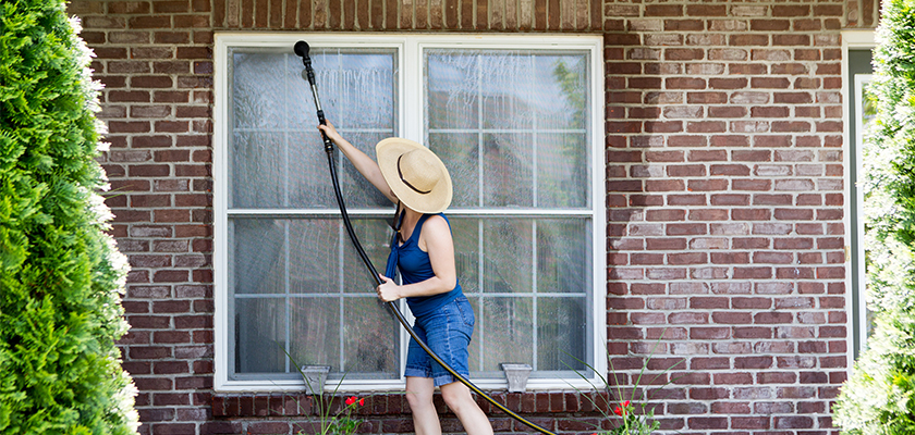 Woman washing windows for spring maintenance | SHW Blog