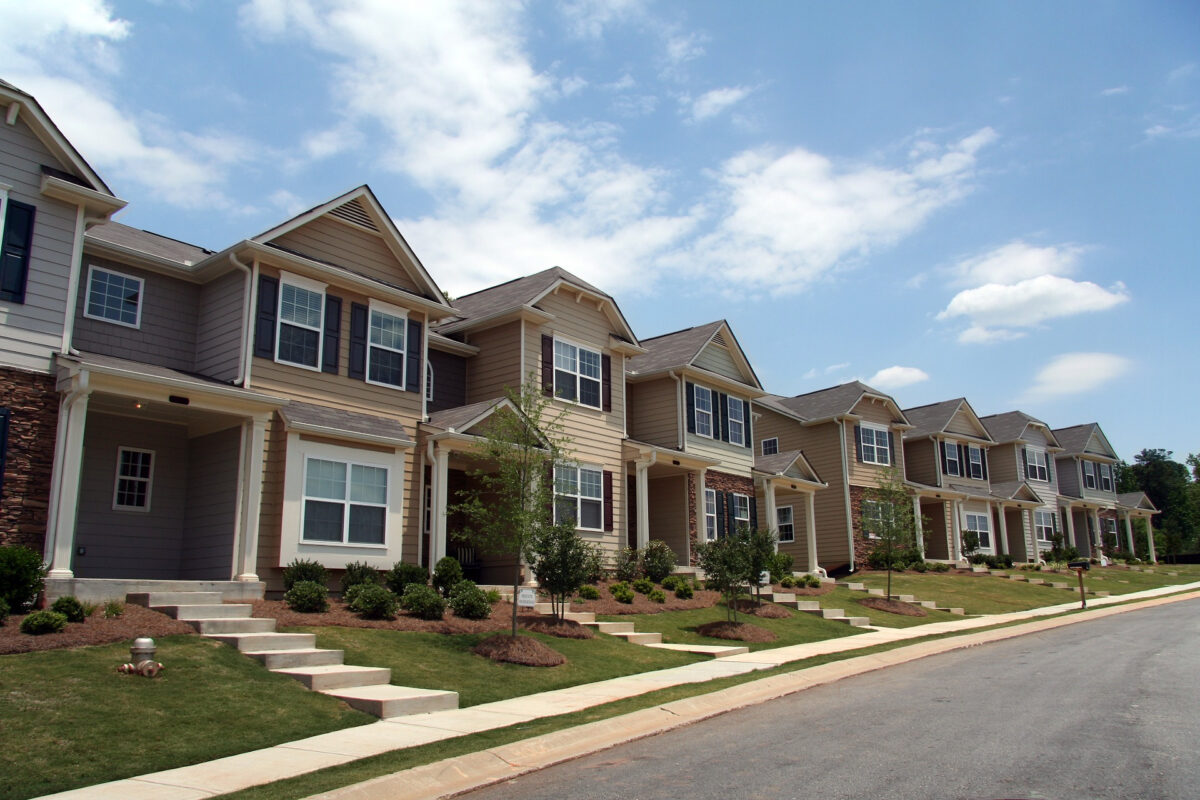 Town homes in a row on a partly cloudy day.