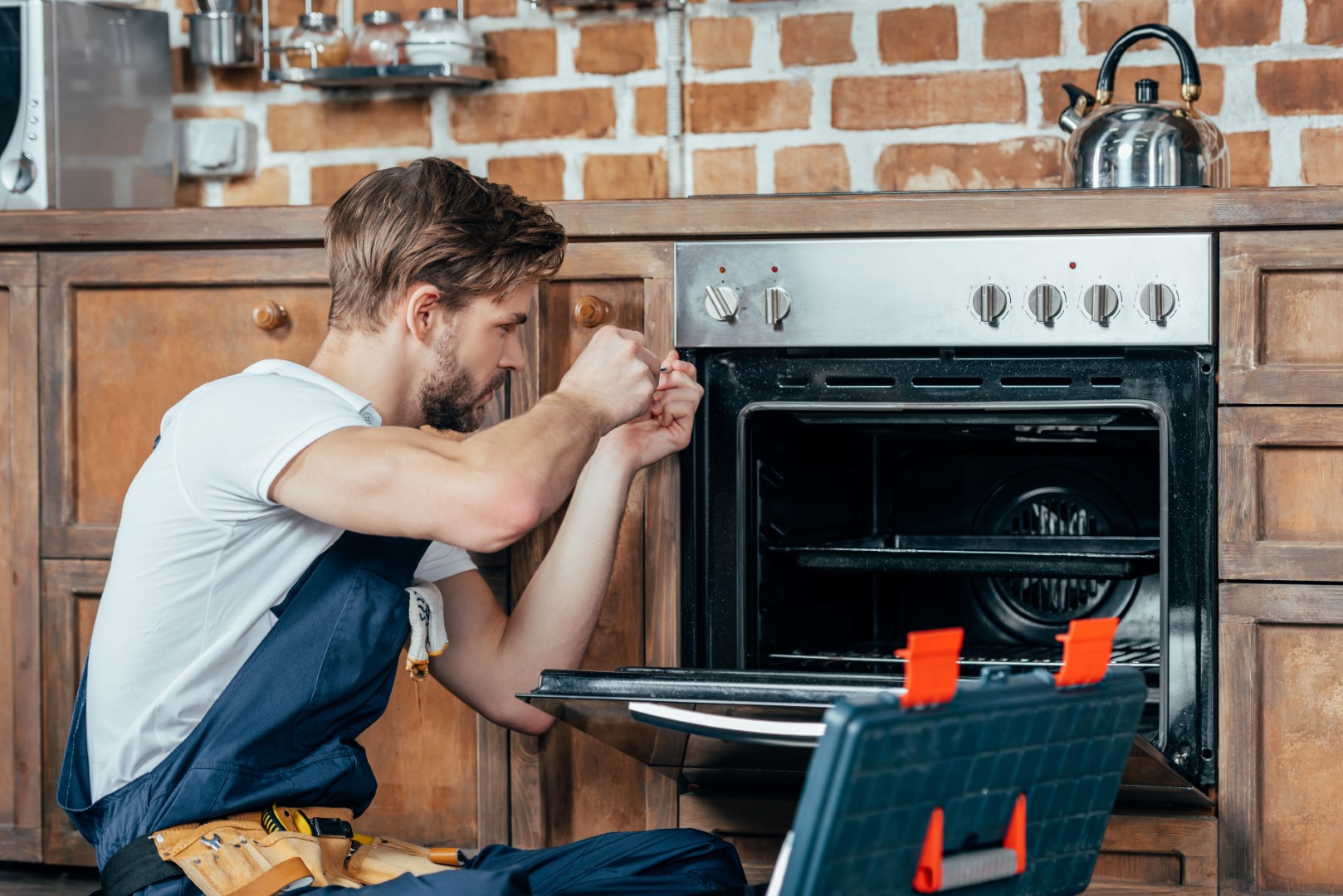 Man repairing a malfunctioning oven.