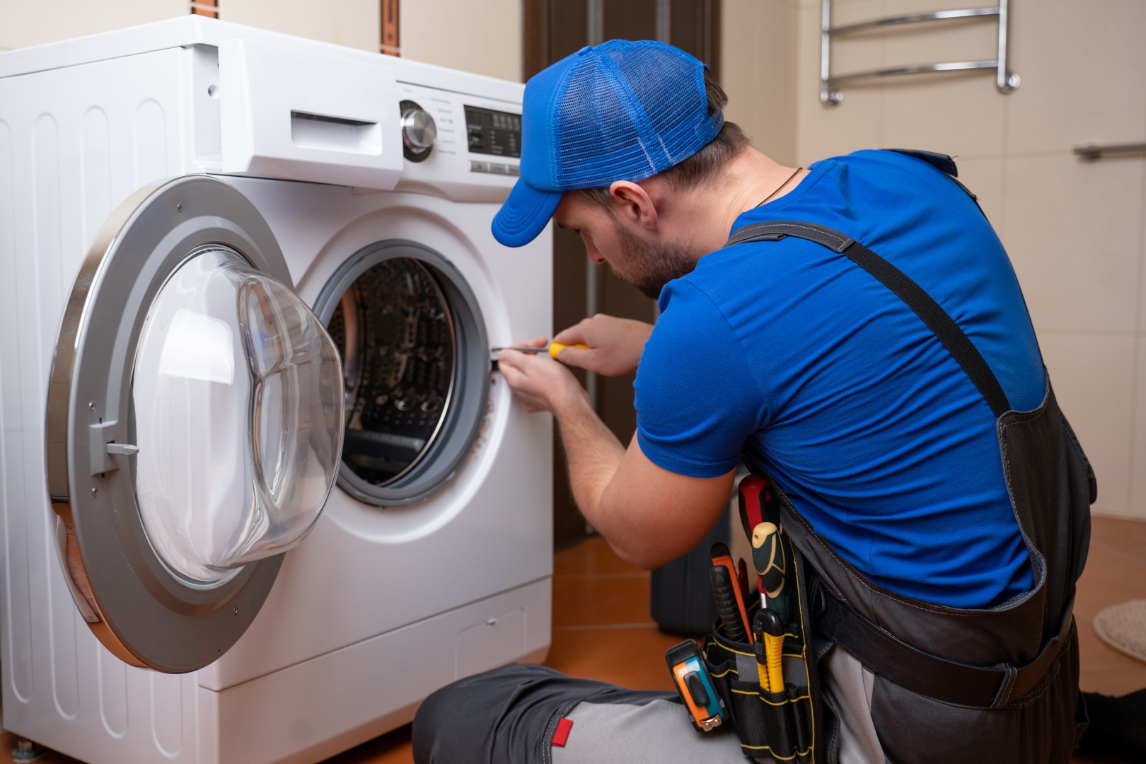 Service tech fixing issues with a broken washing machine.